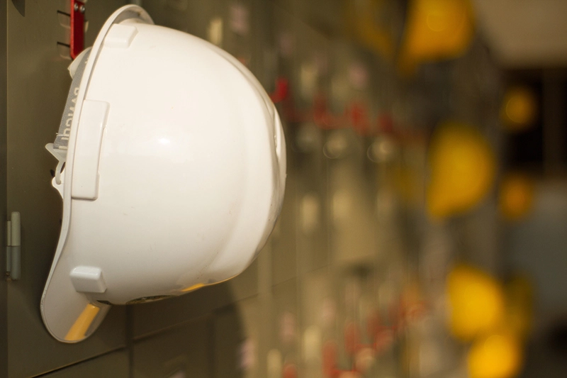 A hard-hat hanging on a metal locker